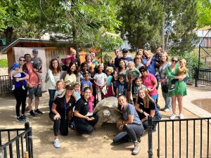 Large group with large Galapagos Tortoise. Celebrating member event at America's Teaching Zoo.